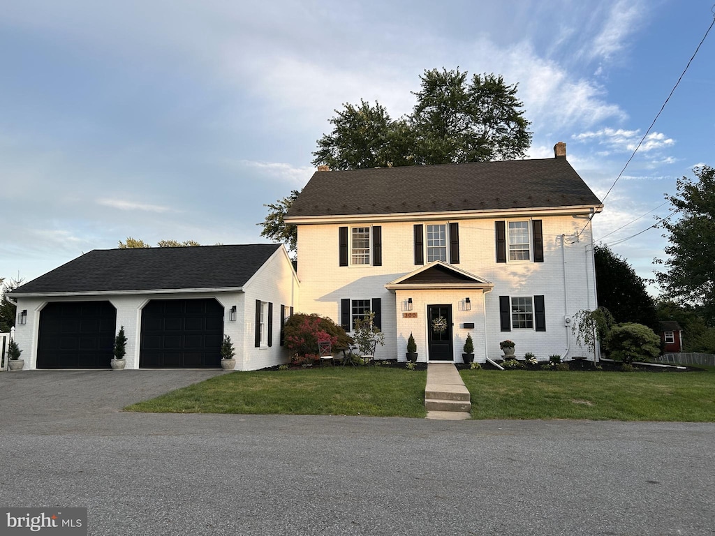 colonial house with a garage and a front yard