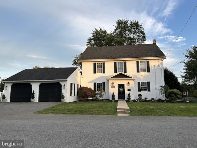 colonial-style house with a garage and a front lawn