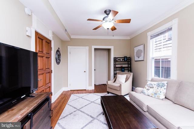 living room featuring crown molding, light hardwood / wood-style floors, and ceiling fan