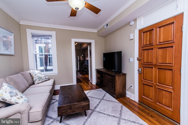 living room with ceiling fan, ornamental molding, and dark hardwood / wood-style flooring