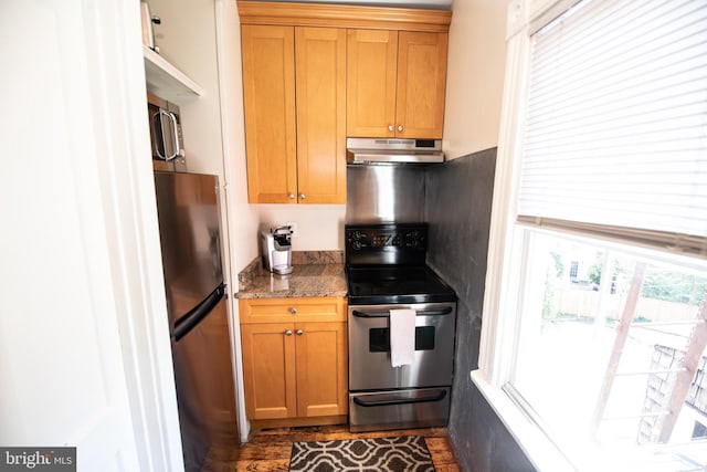 kitchen with stainless steel appliances and dark stone countertops