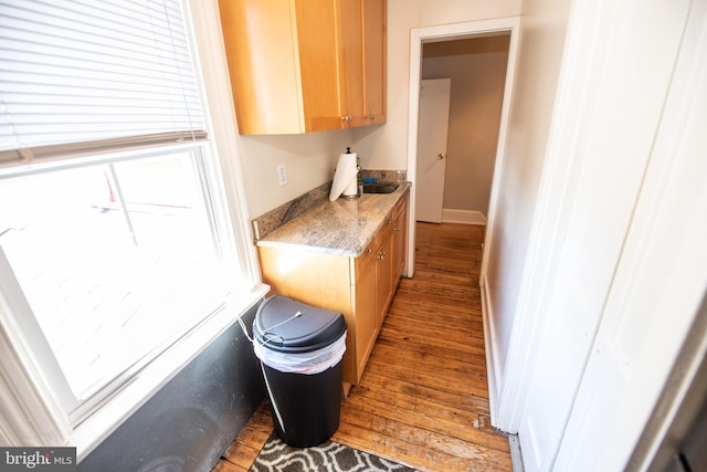 kitchen featuring hardwood / wood-style flooring and light stone countertops