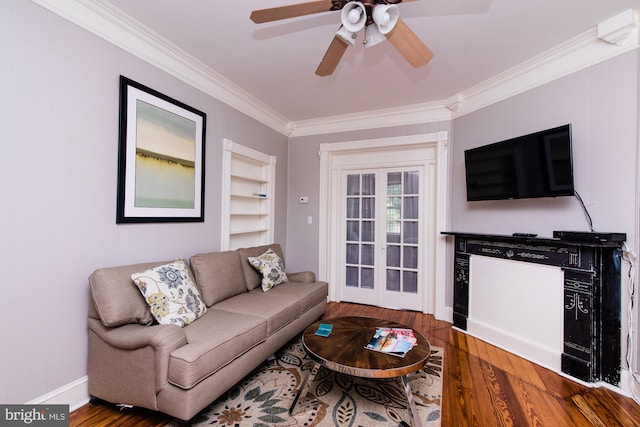 living room featuring wood-type flooring, ornamental molding, and ceiling fan