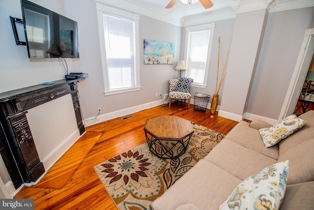 living room featuring ceiling fan, a healthy amount of sunlight, ornamental molding, and hardwood / wood-style floors