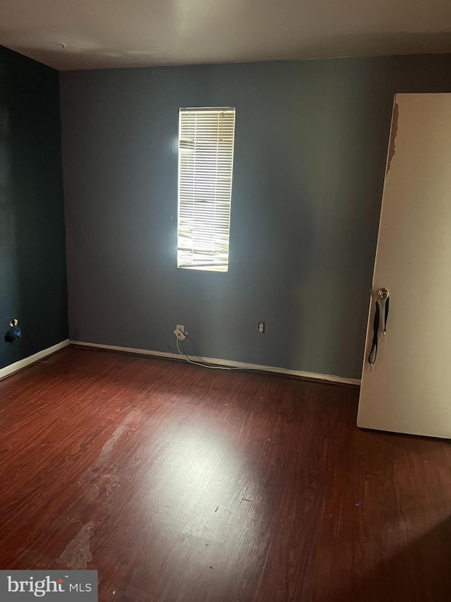 unfurnished room with dark hardwood / wood-style flooring