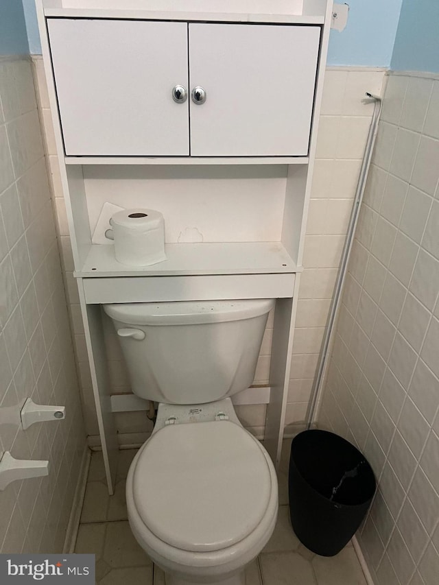 bathroom featuring tile walls, tile patterned floors, and toilet