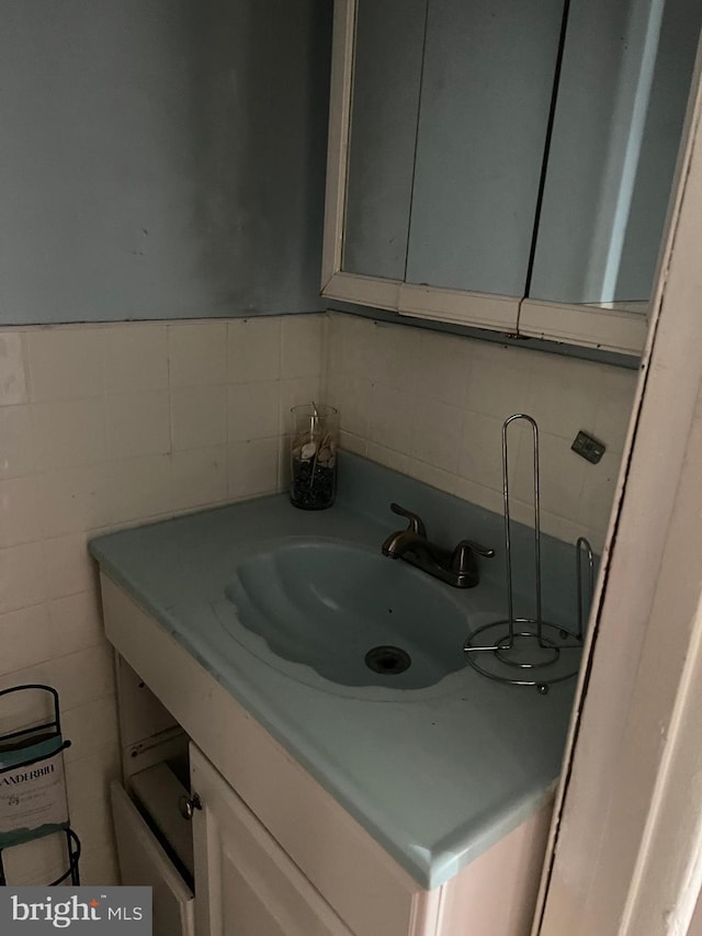 bathroom featuring vanity and tile walls