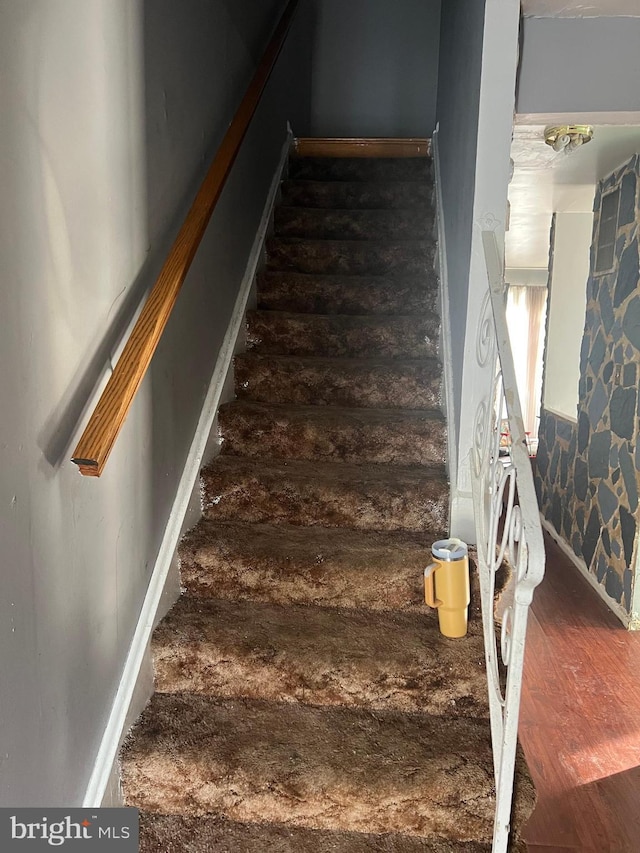 staircase with wood-type flooring