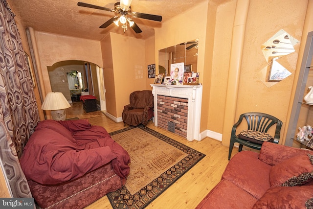 living room with wood-type flooring, a textured ceiling, and ceiling fan