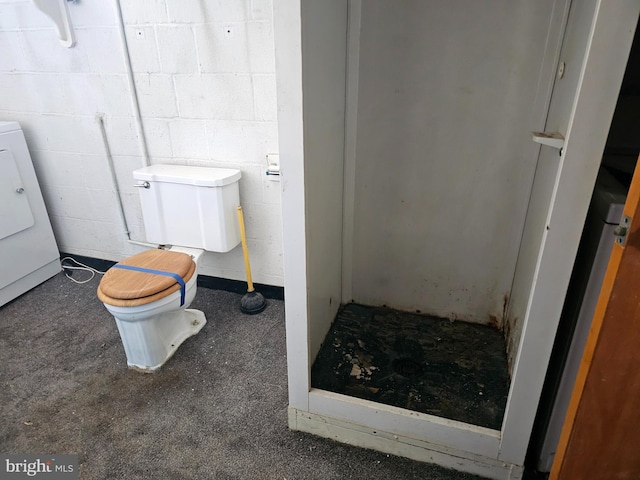 bathroom featuring toilet and washer / clothes dryer