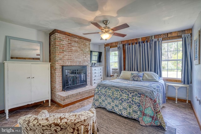 bedroom with ceiling fan and a brick fireplace