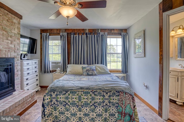 bedroom featuring light tile patterned floors, sink, ceiling fan, cooling unit, and a fireplace