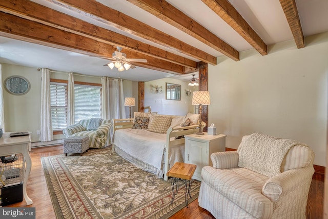 living room with ceiling fan, wood-type flooring, beam ceiling, and a baseboard heating unit