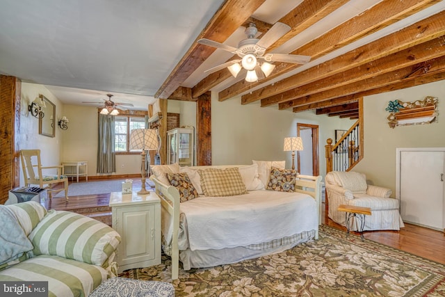 living room with ceiling fan, wood-type flooring, and beam ceiling