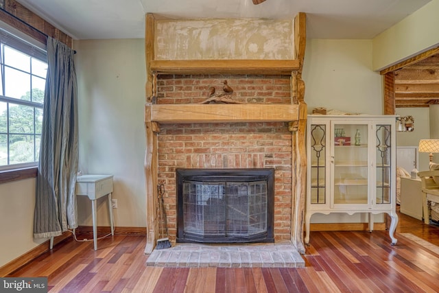 living room featuring wood-type flooring and a brick fireplace