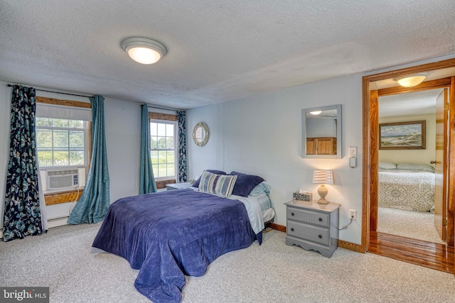 carpeted bedroom featuring a baseboard radiator, cooling unit, and a textured ceiling