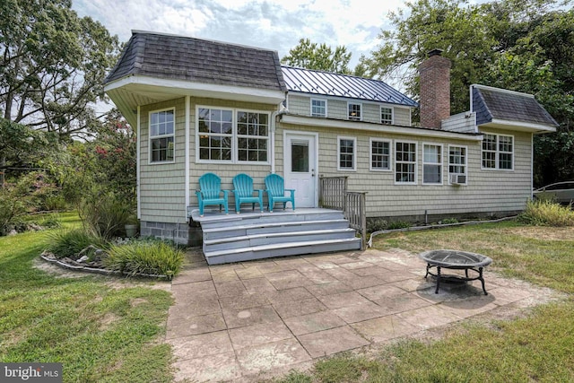 rear view of property with cooling unit, a yard, a fire pit, and a patio area