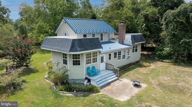 back of property featuring a yard and a fire pit