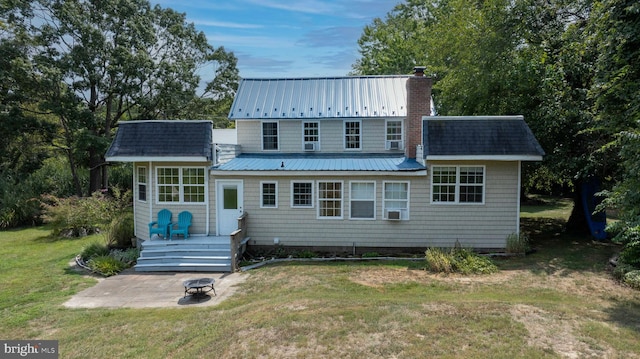 back of property featuring a yard, cooling unit, a patio area, and a fire pit