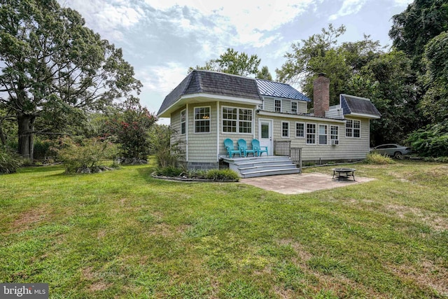 back of house with a wooden deck, an outdoor fire pit, a yard, and a patio