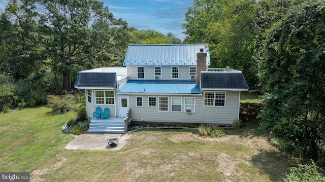 back of property featuring a wooden deck and a yard