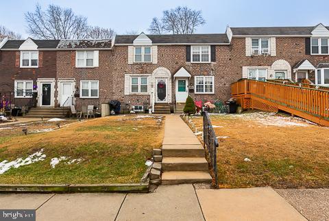 townhome / multi-family property featuring a front lawn