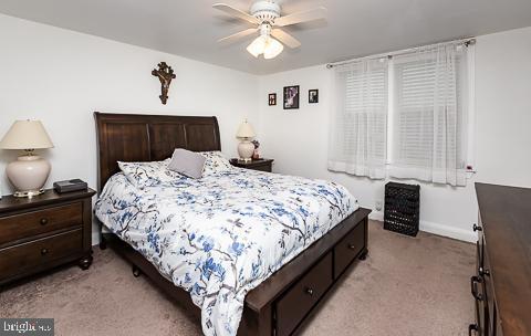 bedroom with ceiling fan and light colored carpet