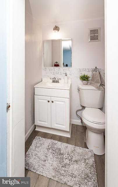 bathroom featuring vanity, toilet, and hardwood / wood-style floors