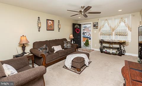 carpeted living room featuring ceiling fan