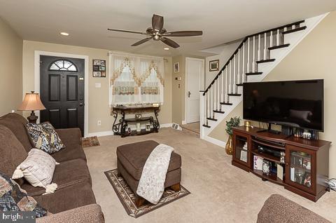 carpeted living room with ceiling fan