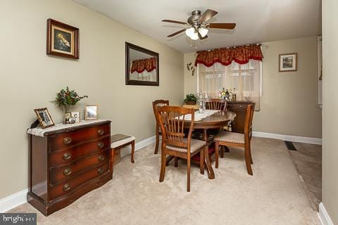 dining area with light colored carpet and ceiling fan