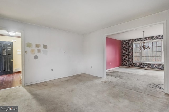 carpeted empty room with a chandelier