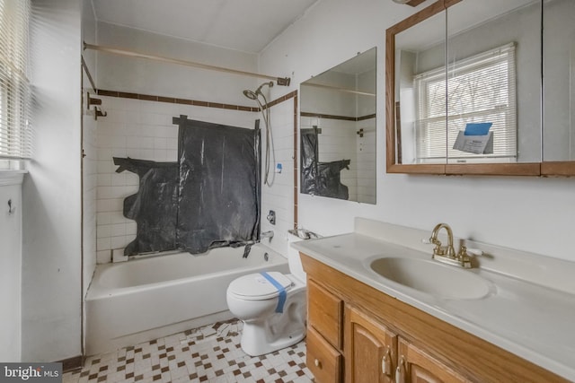 full bathroom featuring tiled shower / bath, vanity, and toilet