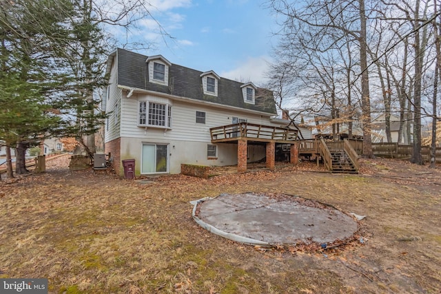 rear view of house with a wooden deck and central air condition unit