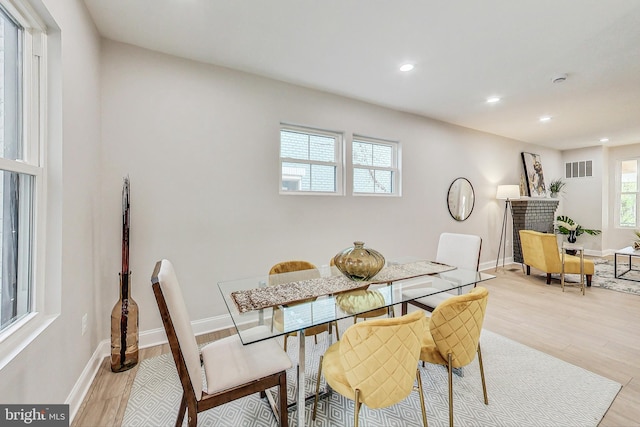 dining area featuring a fireplace and light hardwood / wood-style floors