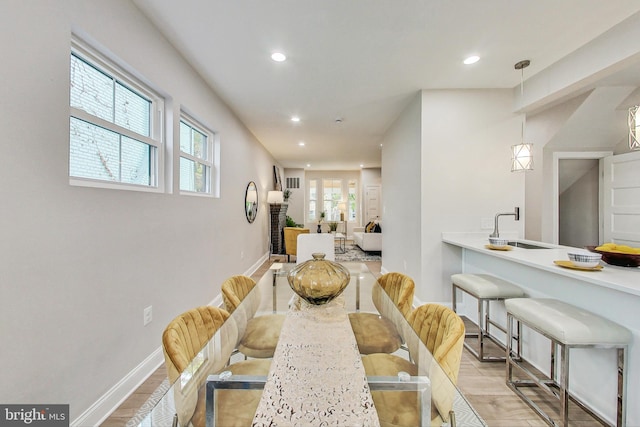 dining area with light hardwood / wood-style floors and sink