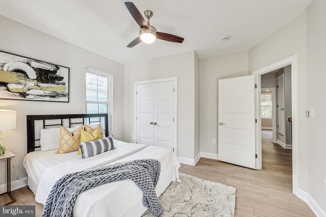 bedroom featuring ceiling fan, light hardwood / wood-style floors, and a closet