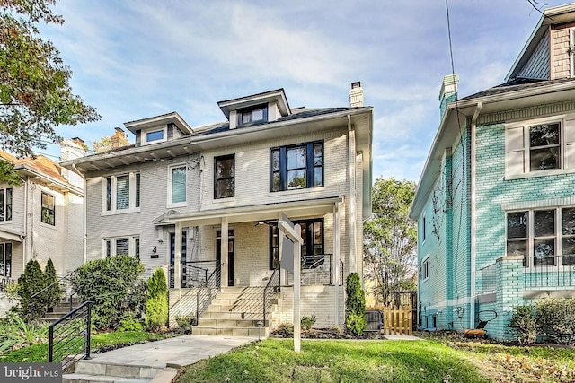 townhome / multi-family property with a front yard and a porch