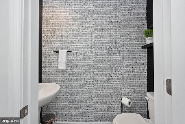 bathroom featuring tile walls and toilet