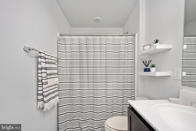 bathroom featuring vanity, curtained shower, and toilet