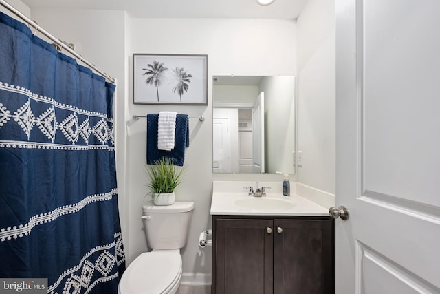 bathroom featuring vanity, walk in shower, and toilet