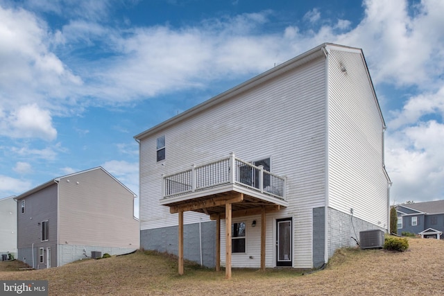 rear view of property with a wooden deck, a lawn, and central air condition unit