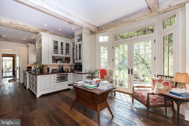 kitchen featuring french doors, white cabinetry, stainless steel microwave, and beam ceiling