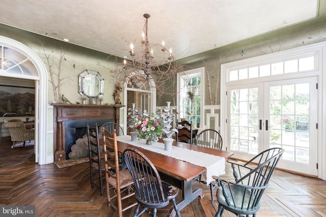 dining area with parquet flooring, a notable chandelier, and french doors