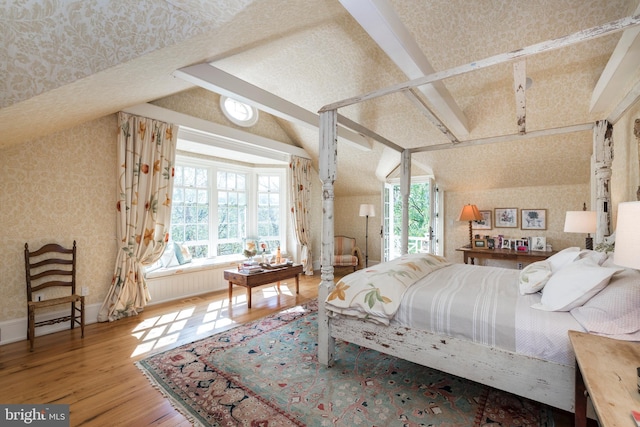 bedroom featuring hardwood / wood-style flooring, vaulted ceiling, and multiple windows