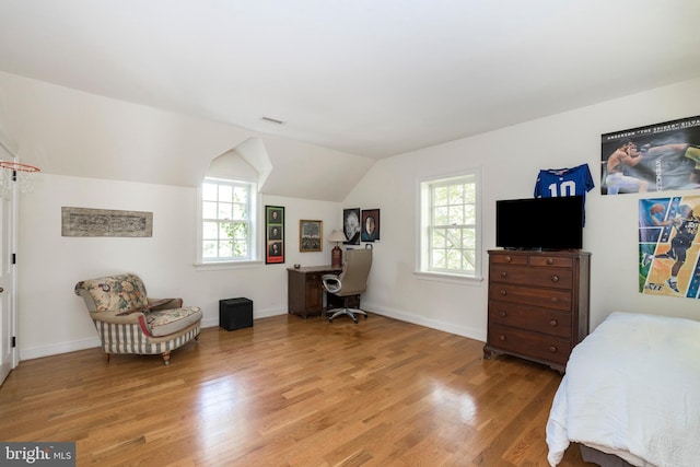 bedroom with lofted ceiling and light wood-type flooring