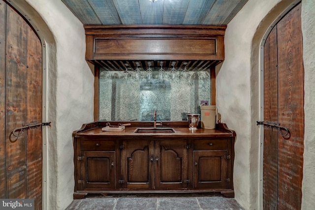 bar featuring sink and dark brown cabinets