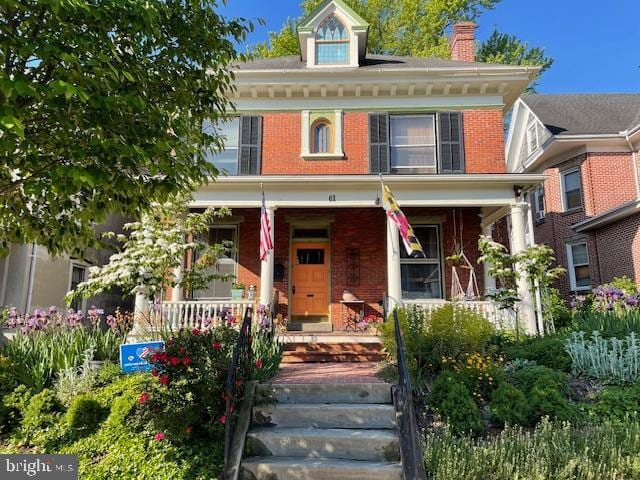 view of front facade featuring a porch and brick siding