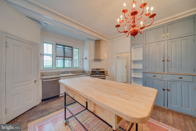 kitchen featuring wall chimney range hood, appliances with stainless steel finishes, hanging light fixtures, hardwood / wood-style floors, and ornamental molding