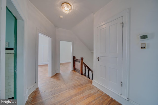 hallway with lofted ceiling and light hardwood / wood-style flooring